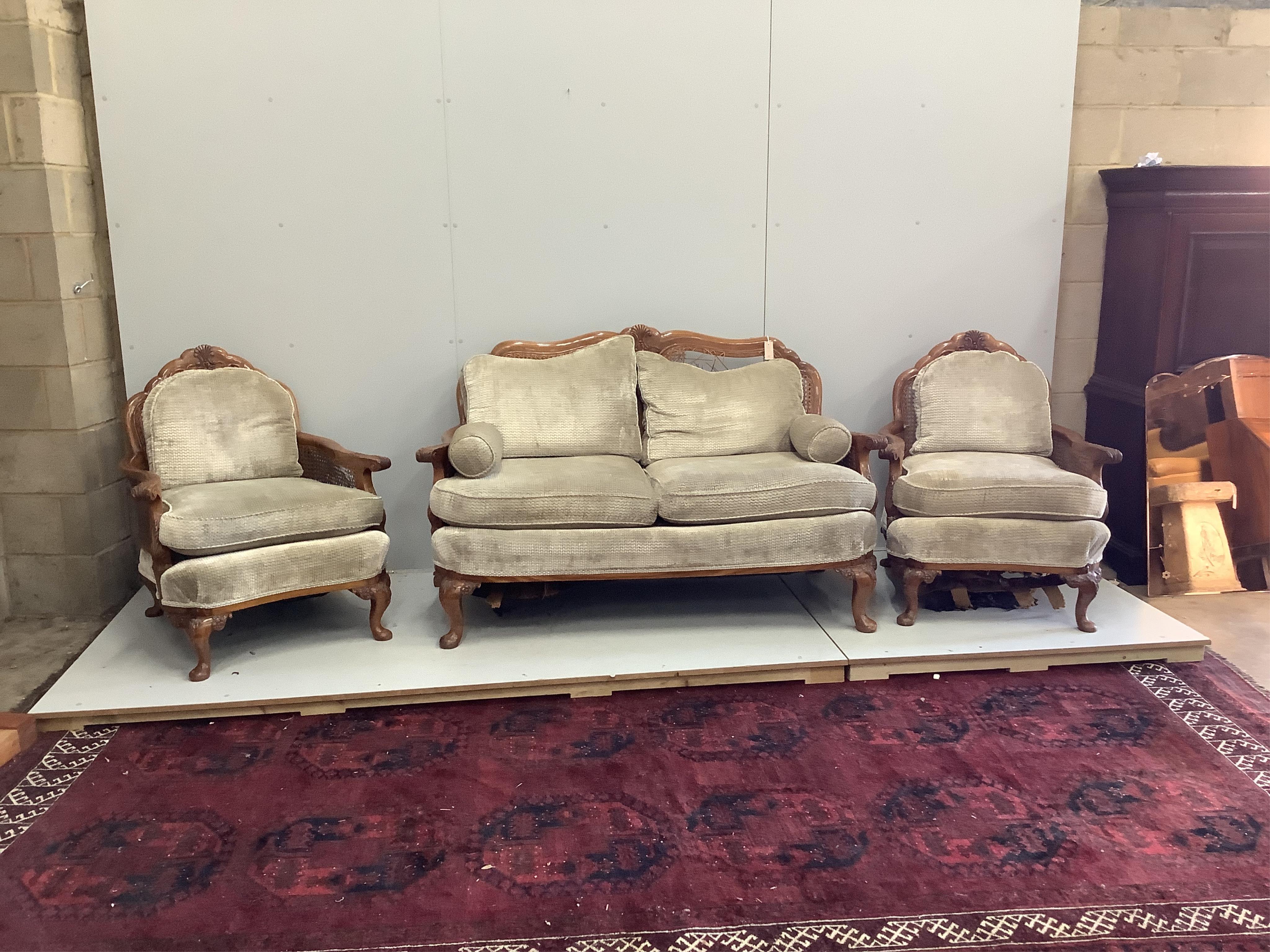 A Queen Anne Revival walnut three piece Bergere suite, cane in need of extensive repair, settee width 156cm, depth 74cm, height 94cm. Condition - poor